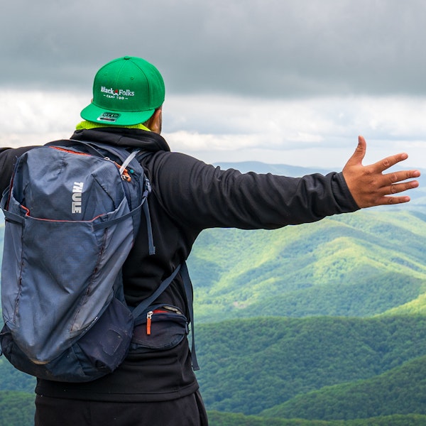 Hiker with a Black Folks Camp Too hat enjoying the mountains.