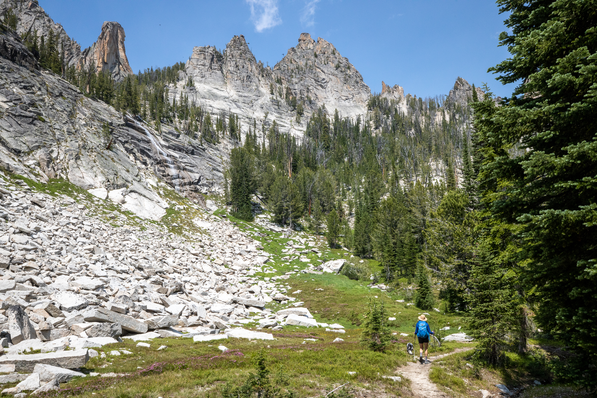 Woman trekking through the mountains in Oboz hiking shoes with dog 
