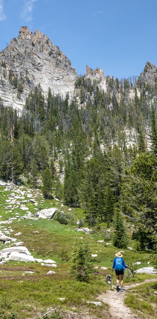 Woman trekking through the mountains in Oboz hiking shoes with dog