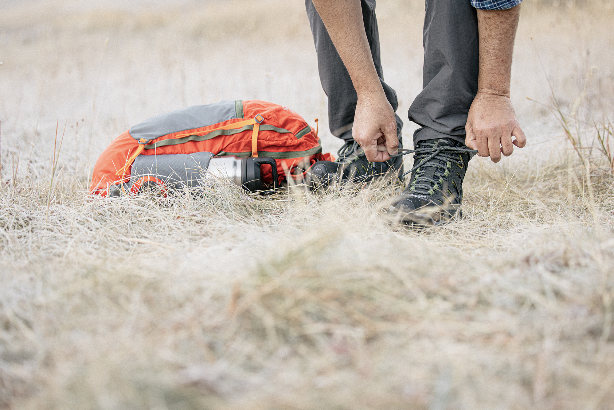 Hiker lacing up the Oboz Sawtooth II Mid boots.