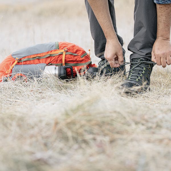 Hiker lacing up the Oboz Sawtooth II Mid boots.