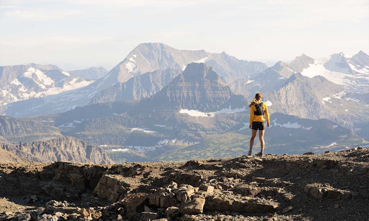 A woman looks out over a mountain view while hiking in her Oboz hiking boots.