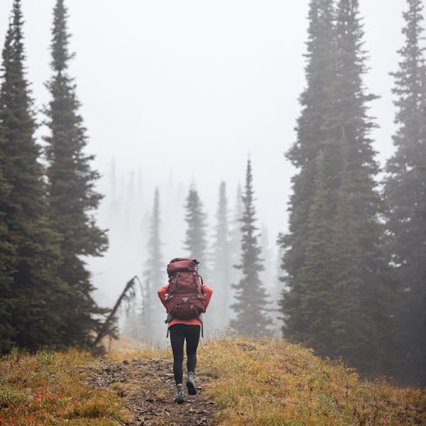 Backpacker in the Oboz Sawtooth X hiking boot on a backcountry trail.