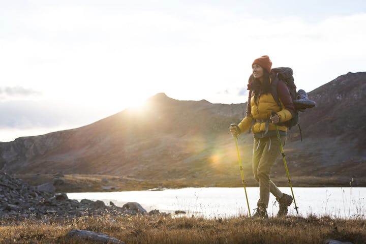 Woman hiking in Oboz Bridger Mid hiking boots past an alpine lake in the fall.