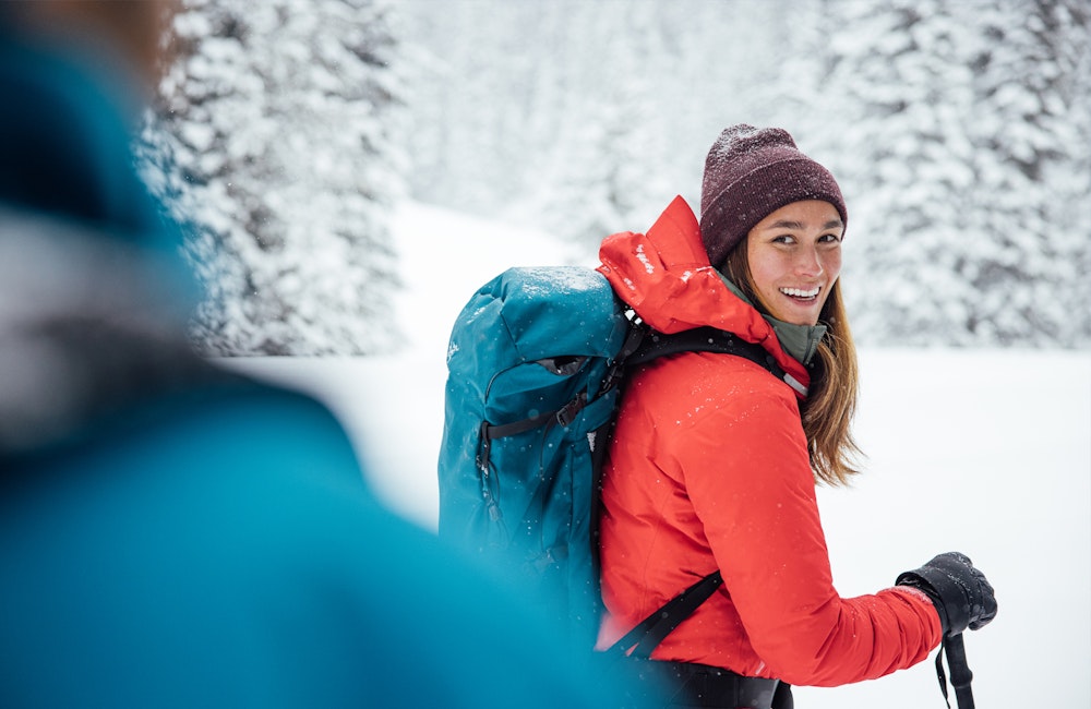 Woman smiling while on a snowy trail