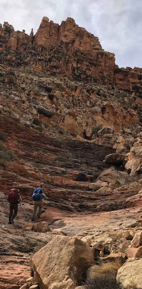 Two hikers hiking up the ridge