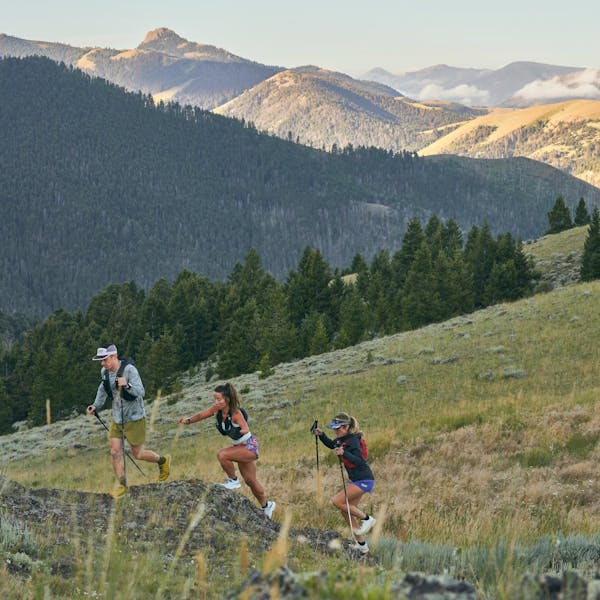 Group of hikers trail running up a mountain in Montana wearing Oboz trail shoes.