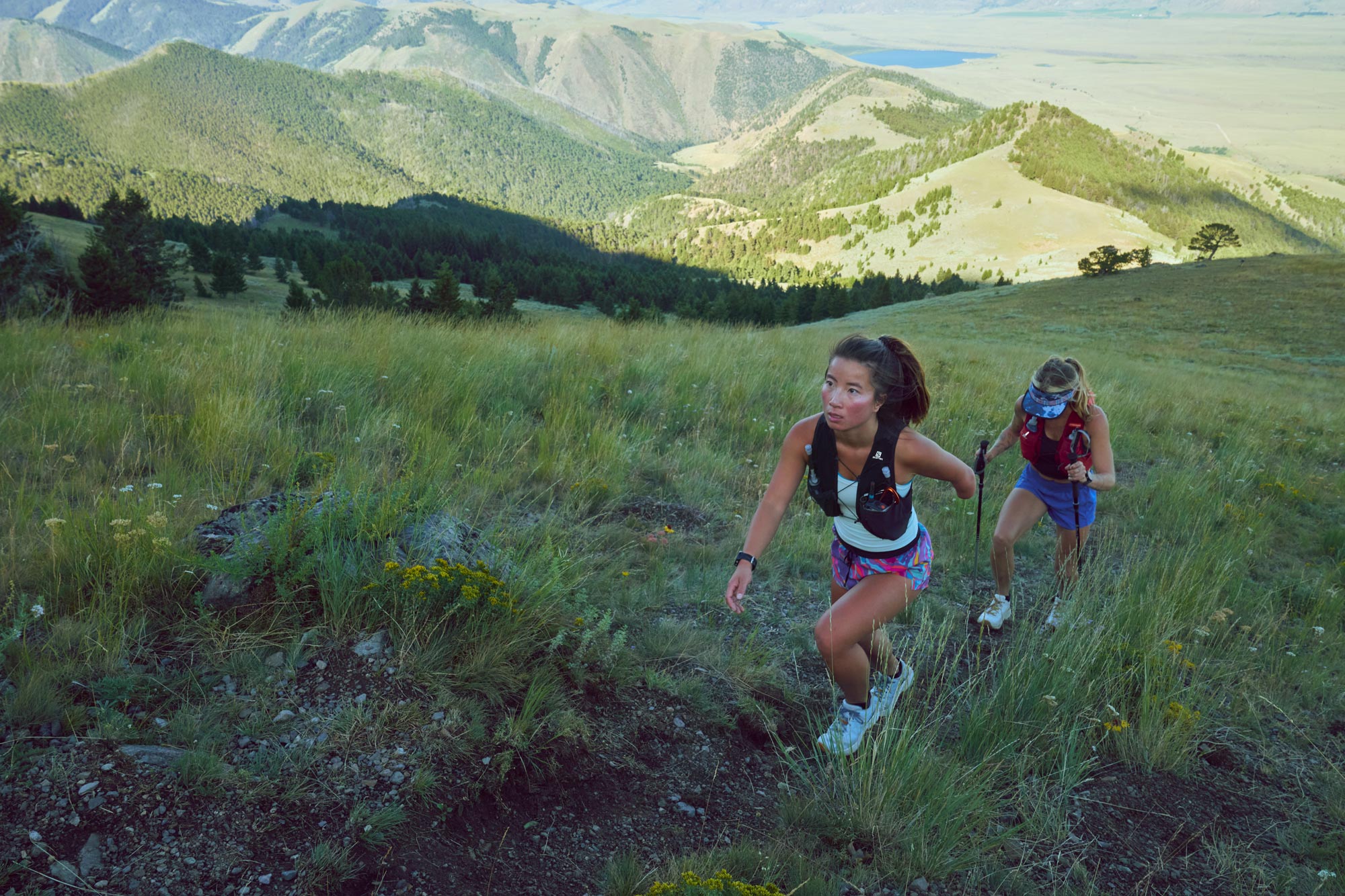 Two women climbing a mountain in Montana on a dirt trail.
