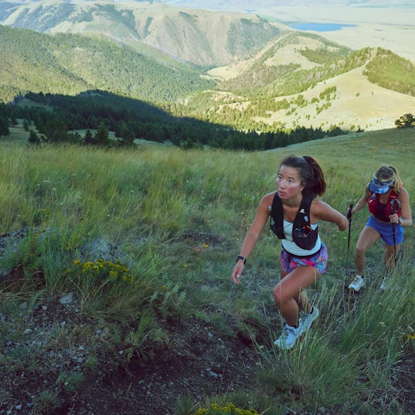 Two women climbing a mountain in Montana on a dirt trail.