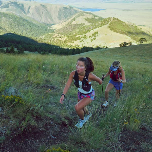 Two women climbing a mountain in Montana on a dirt trail.