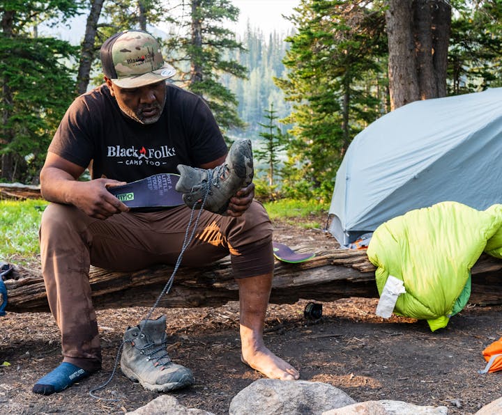 Earl Hunter Jr putting a Black Folks Camp Too insole into an Oboz Bridger Mid boot.