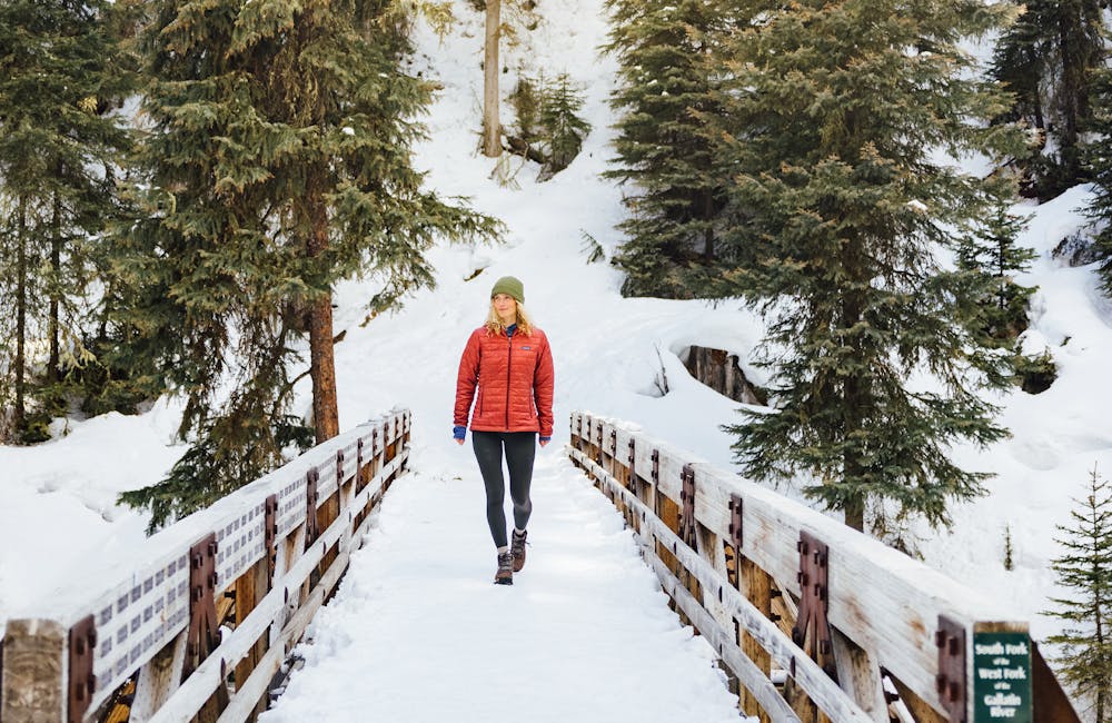 Walker on a bridge in the winter wearing Oboz Sphinx boots.