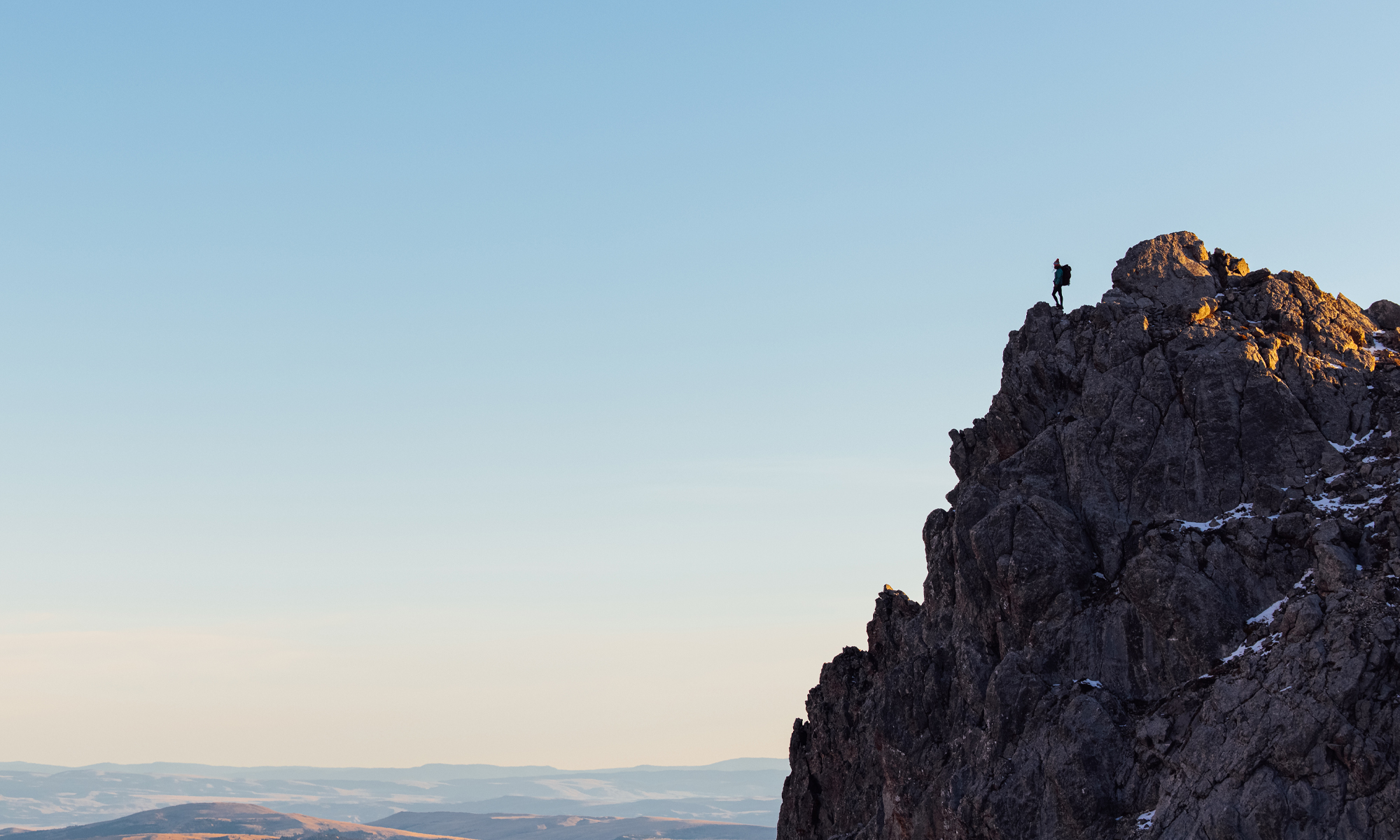 A hiker on a granite mountain top wearing Oboz hiking boots.