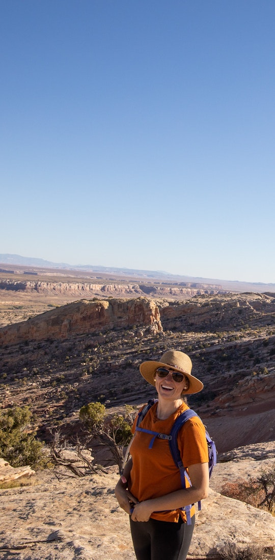 Happy woman hiking in Utah Bear Ears on a sunny day.