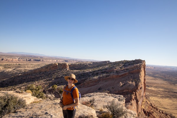 Happy woman hiking in Utah Bear Ears on a sunny day.