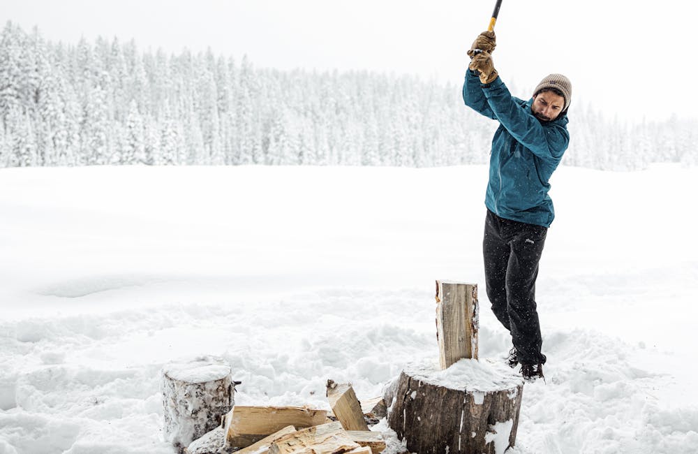 Chopping wood in cold winter conditions wear Oboz winter boots.