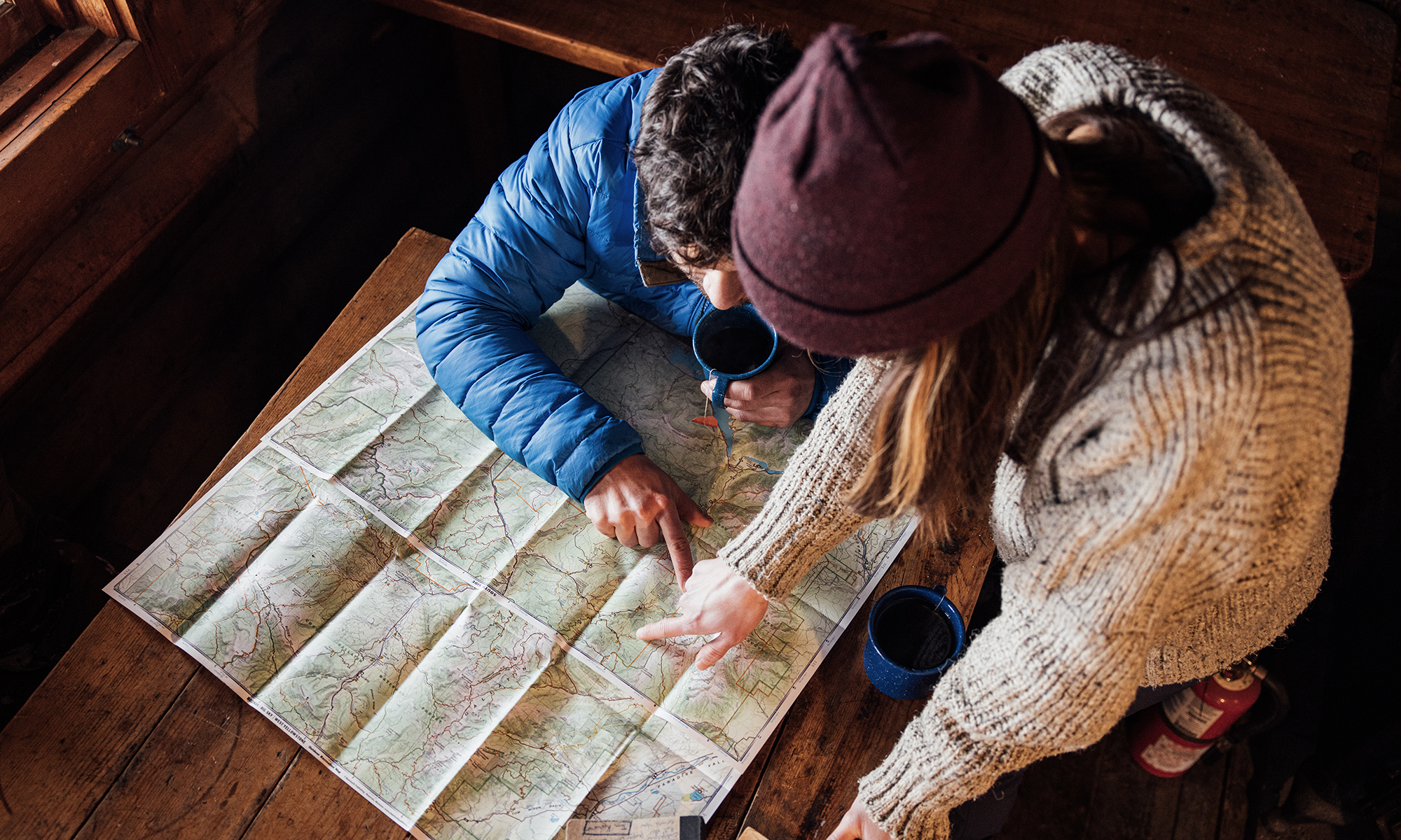 Two people planning their hiking route using a physical map.