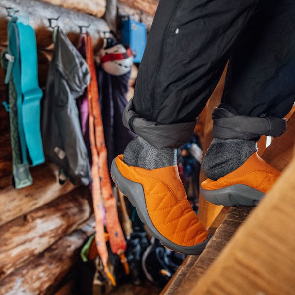 Oboz Whakatā Puffy Low slipper climbing stairs in a log cabin.