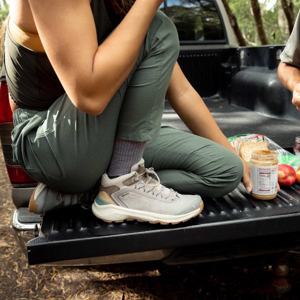 Man and woman eat sandwiches while preparing for a afternoon hike in the Hawaiian wilderness.