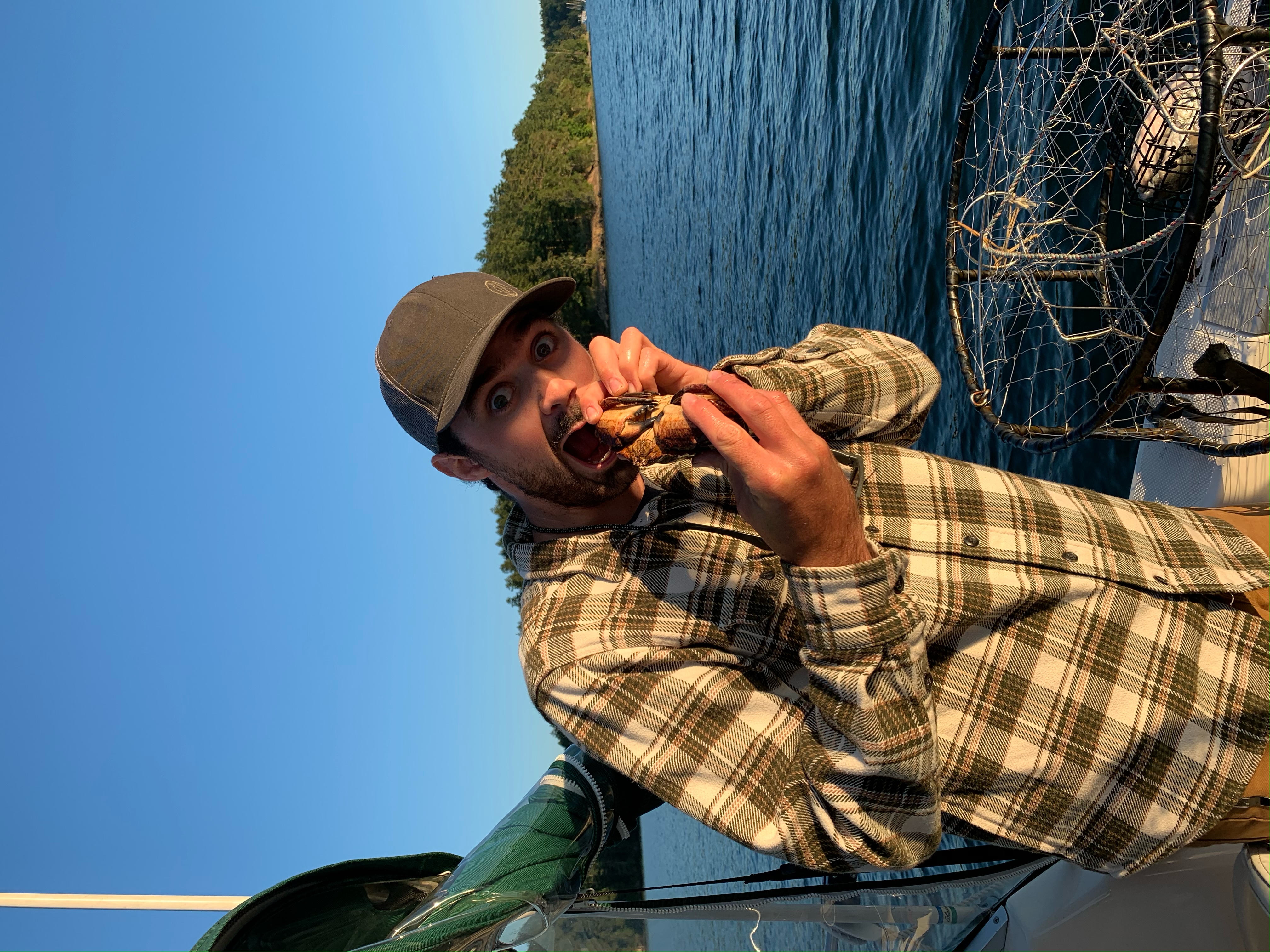 Josh Romano battling a crab while fishing in the ocean.