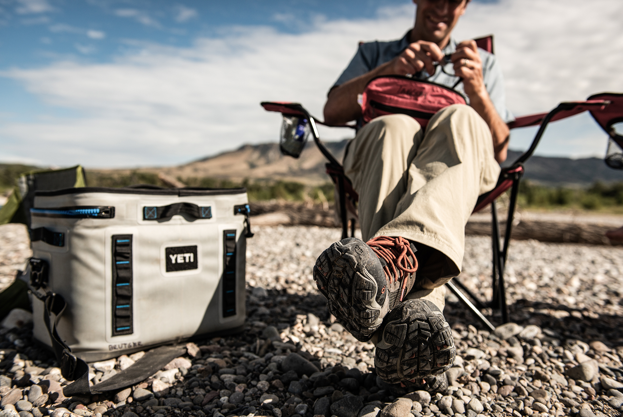 Man relaxing in a camp chair wearing the Oboz Firebrand II Low B Dry shoes.
