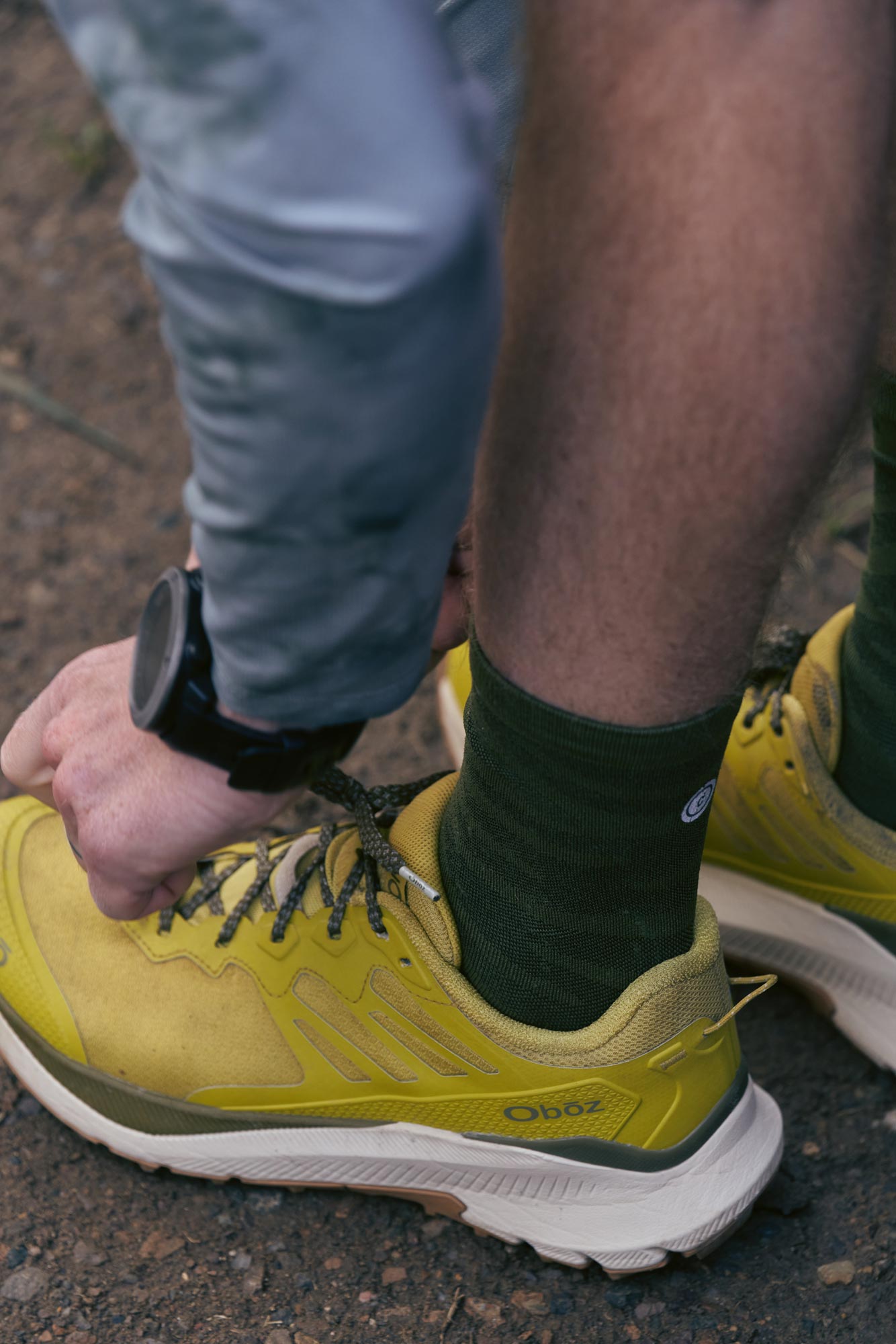 Man tying his shoes in anticipation of a trail run.