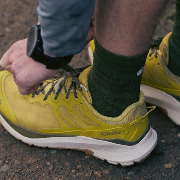 Man tying his shoes in anticipation of a trail run.