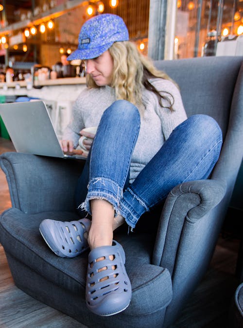 A woman working on a laptop wearing Oboz Whakata Coast sandals.