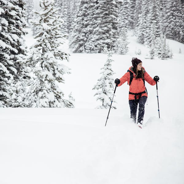 Smiling woman snowshoeing in the Oboz Bridger Insulated Waterproof boot.
