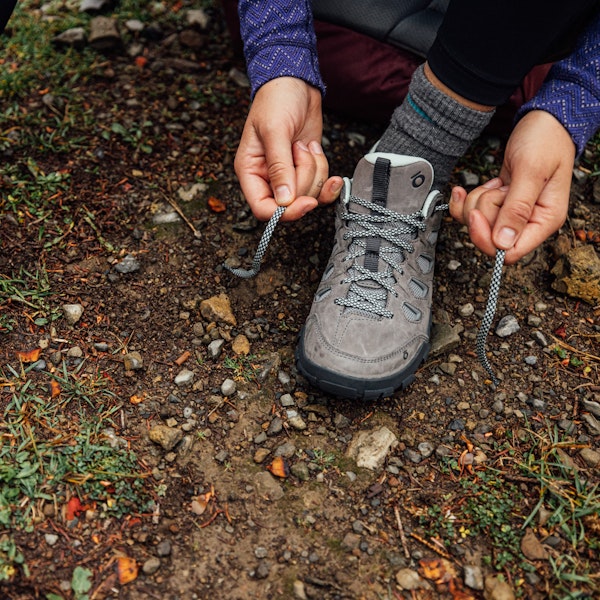 A camper lacing up the Sawtooth X Low.