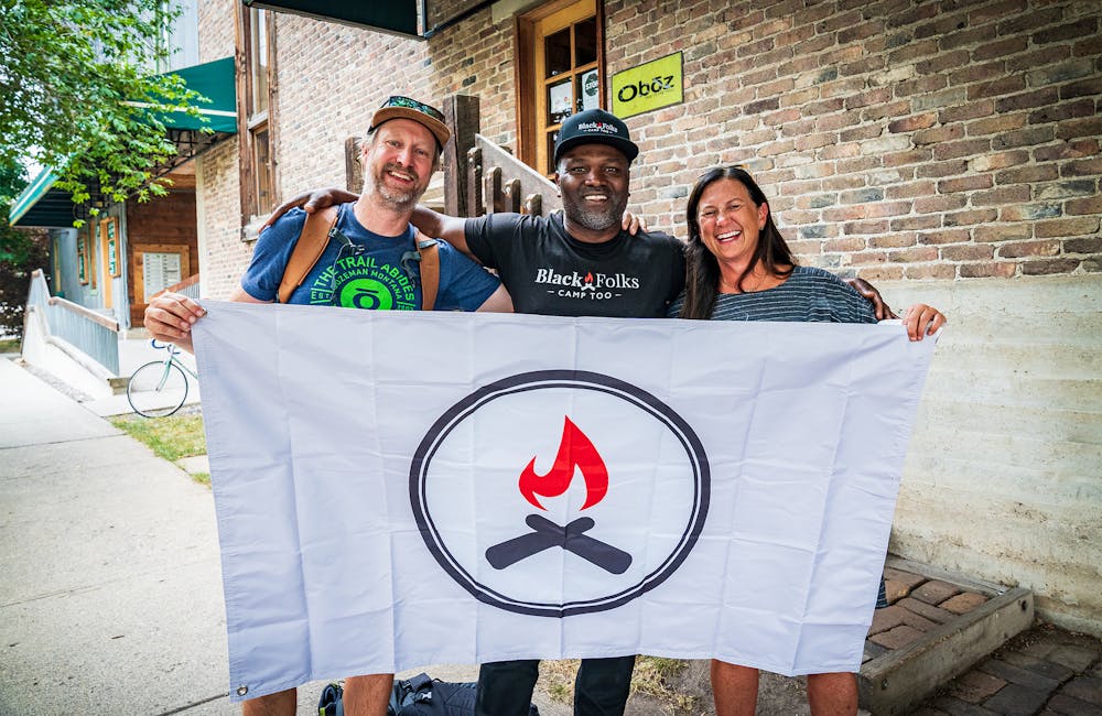 Oboz hiking footwear employees and Earl Hunter Jr with a Black Folks Camp Too flag.