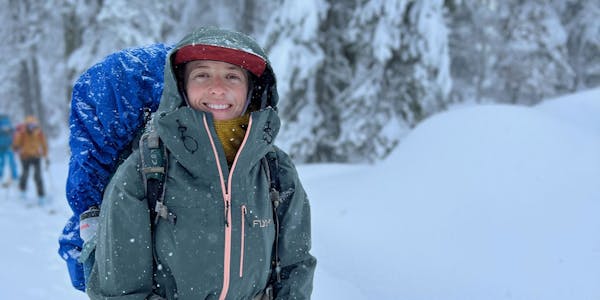 Oboz Trailblazer Ayla Mae Wild smiling on a snowy trail.