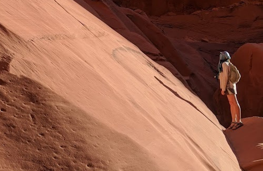 Jeanelle Carpentler looks up a sandstone canyon feature