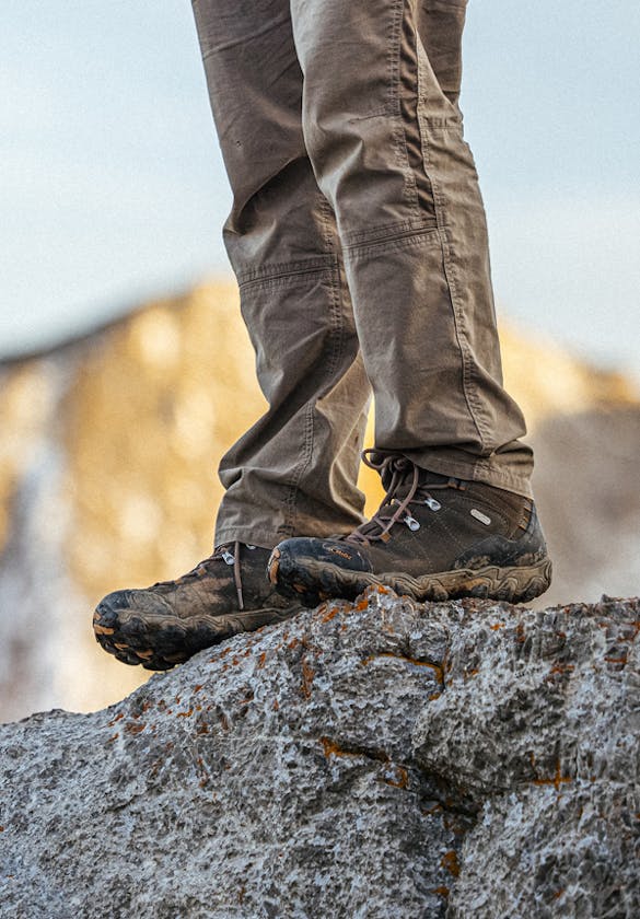 Hiker on a rock outcropping in Oboz Bridger mid hiking boots.
