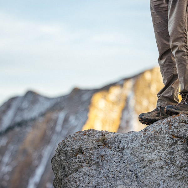 Hiker on a rock outcropping in Oboz Bridger mid hiking boots.