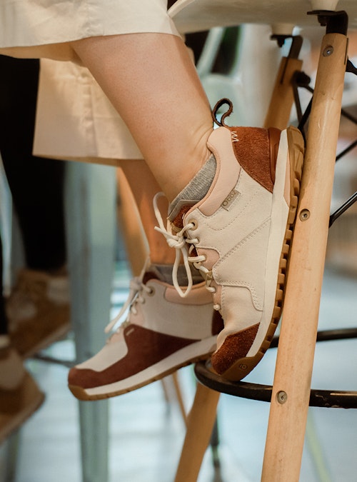 Two women sitting on barstools in Oboz boots