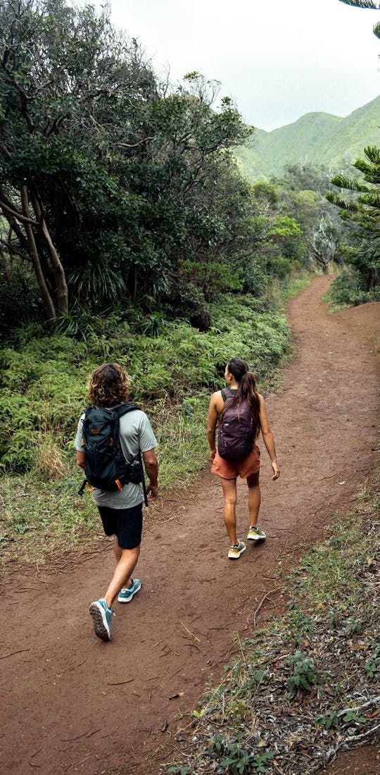 Two people walk through a hiking trail in Hawaii in Oboz Cottonwood hiking shoes.