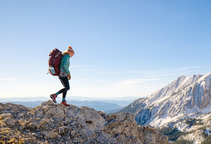 A woman hikes along a mountain ridge in Oboz Bridger hiking boots.