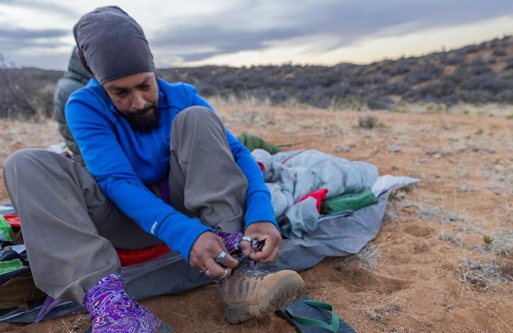 Derrick Lugo tying his Sawtooth X hiking boots.