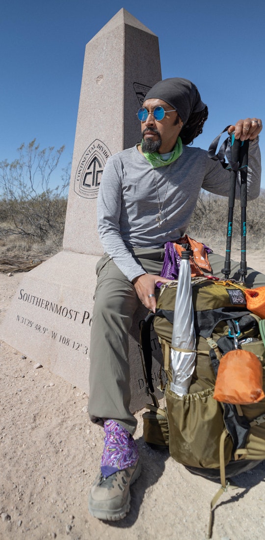 Derick Lugo with his backpacking gear at the Crazy Cook Monument – The CDT’s Southern Terminus.