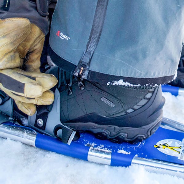 Adjusting snowshoes in the men's Oboz Bridger 10" Insulated Waterproof.
