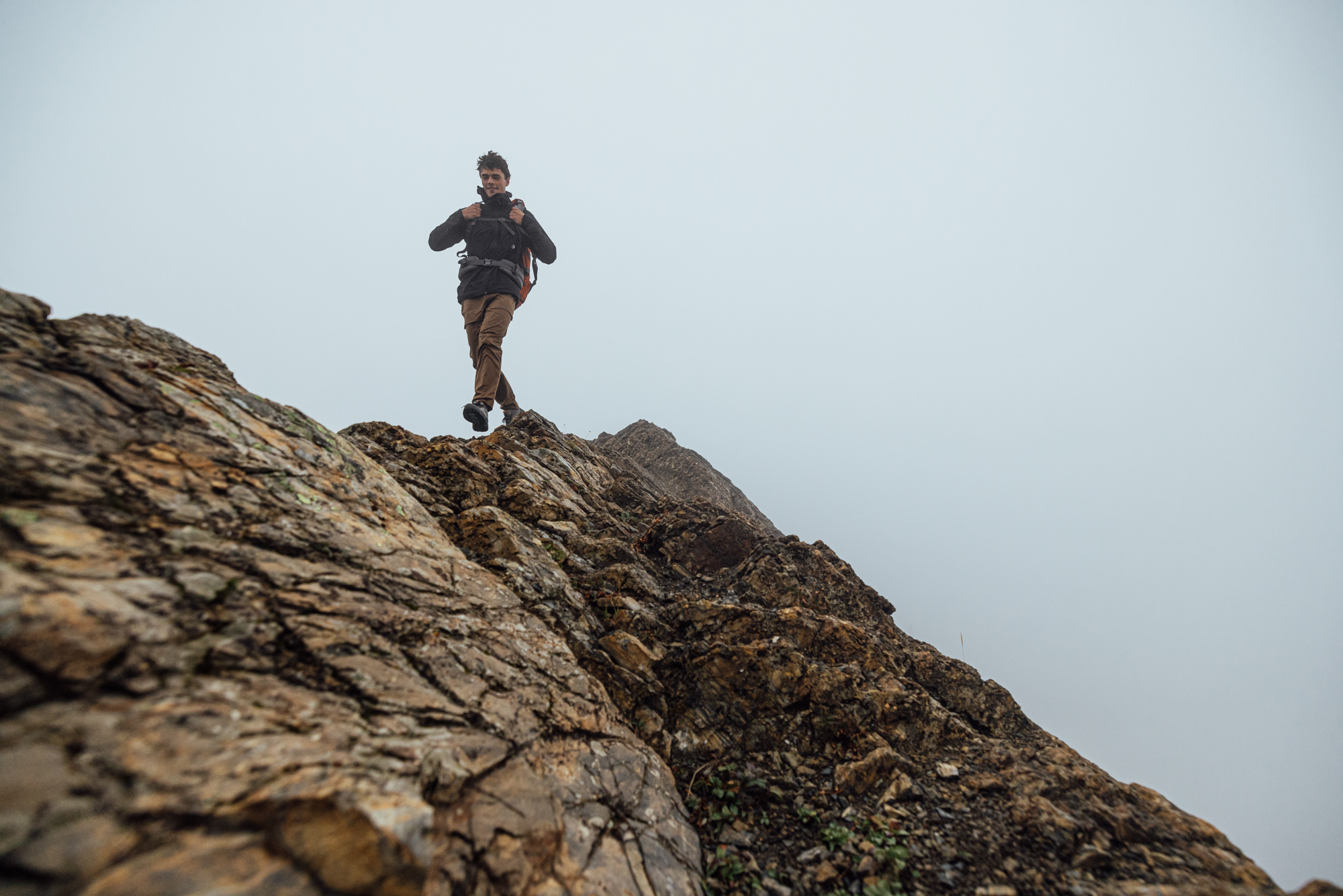 Hiker trekking up a rocky slope in the Sawtooth X hiking boot. 