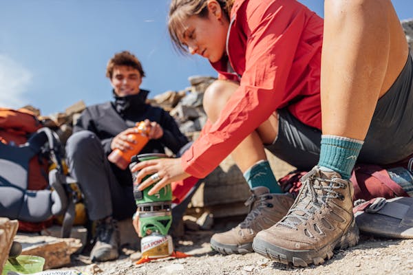 Two hikers in the Oboz Sawtooth X hiking shoe making food at camp.