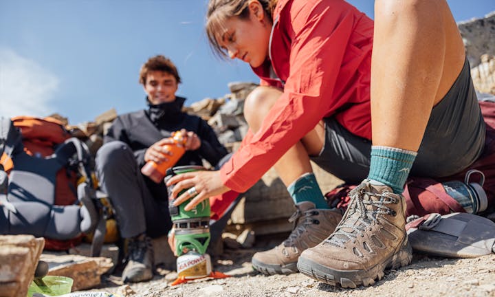 Two hikers in the Oboz Sawtooth X hiking shoe making food at camp.