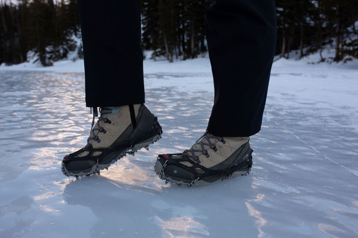 Kylie Yang in Oboz Ousel boot on an icy lake using microspikes for traction. 