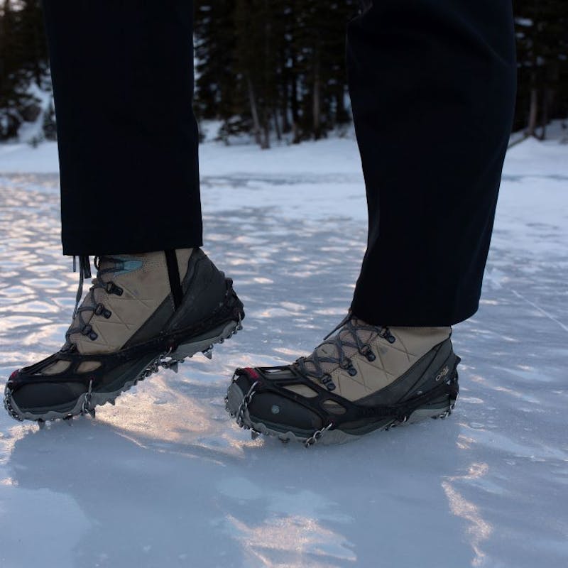 Kylie Yang in Oboz Ousel boot on an icy lake using microspikes for traction.