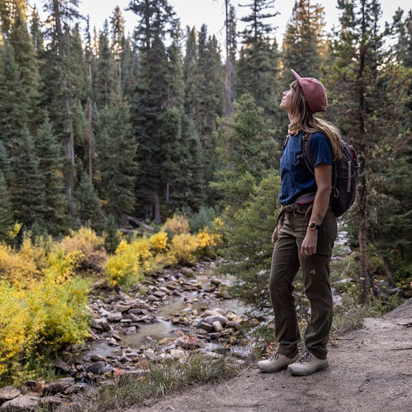 Woman admiring a creek view in the Oboz Ousel hiking boots.