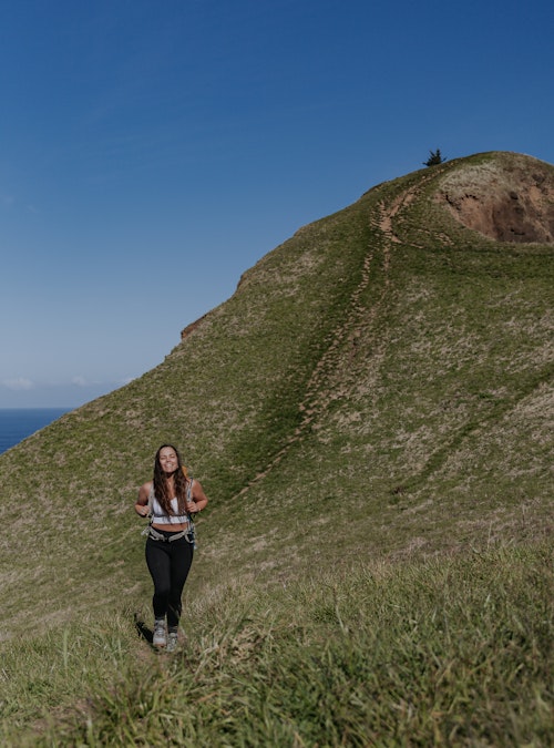 Lindsay Kagalis smiling before summiting a mountain top in the Women's Bozeman Mids