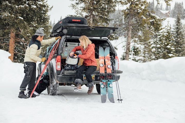 Couple prepares their gear for an adventure in the mountains while wearing Oboz winter insulated boots.