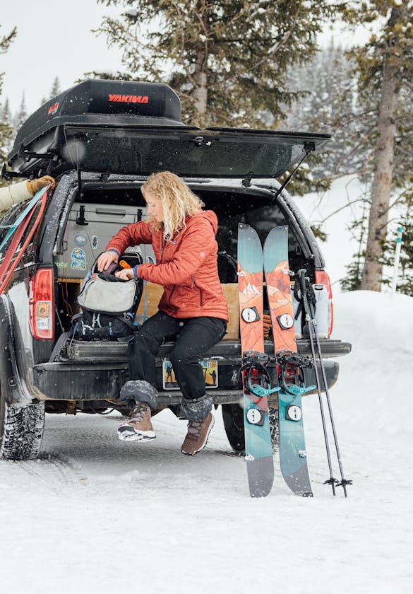 Couple prepares their ski's and backpack's for a backcountry adventure in the mountains while wearing Oboz winter boots.